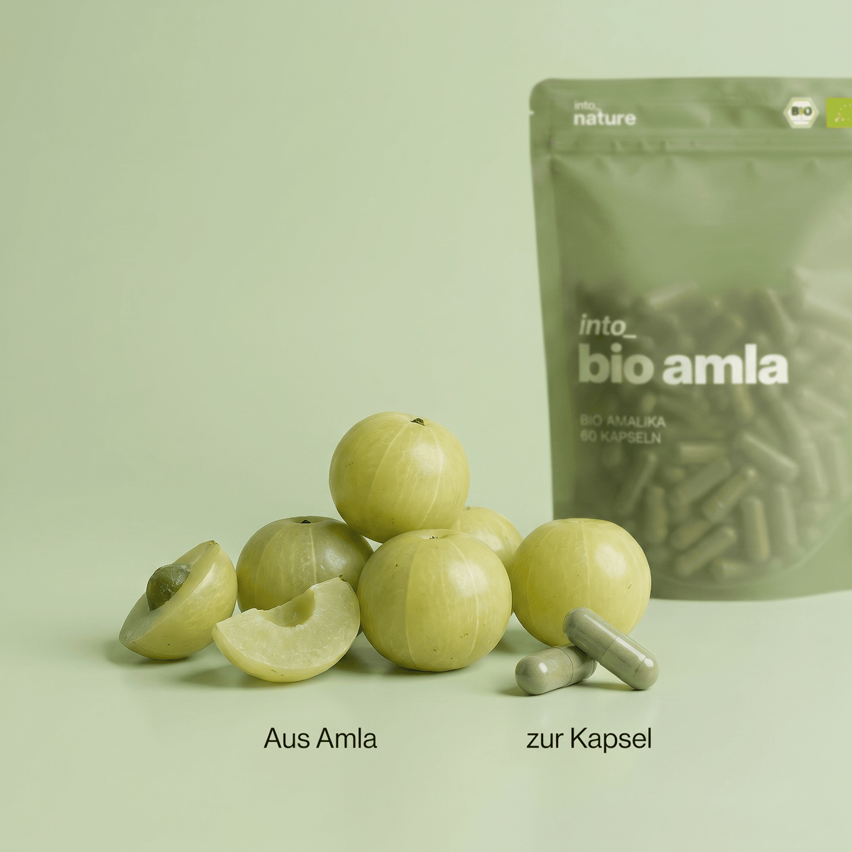 Frische indische Stachelbeere (Amalaki) neben den Bio Amla Kapseln